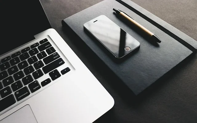 A laptop, pen, and smartphone arranged neatly on a table, showcasing modern techinsiderz.com gadgets and productivity tools.