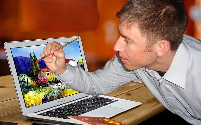 A man using a laptop to create gramhir.pro ai photo generator, highlighting the innovative use of technology in artistic expression.