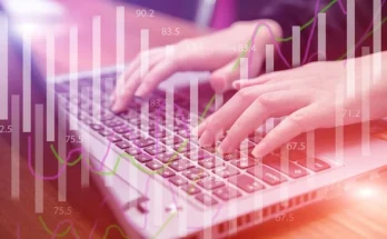 Close-up of hands on a laptop keyboard, analyzing stock market graphs for GomyFinance invest insights.