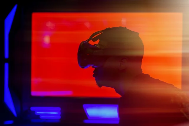 A man wearing a webtub headset stands in front of a screen, engaged in an immersive digital experience.