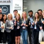 Team members smiling in kitchen workspace – Meet Team TheWeeklySpooncom